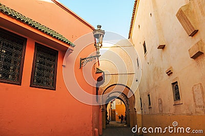 The houses in traditional pink color are on both sides of the small alley. Marrakesh Editorial Stock Photo