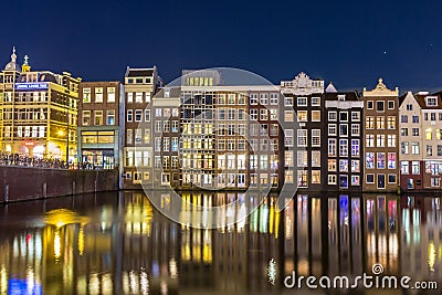 Houses on the Warmou straat reflected in the water of Damrak Editorial Stock Photo