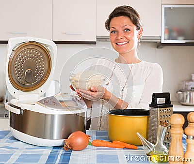 Housewife cooking rice with multicooker Stock Photo