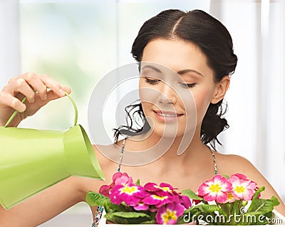 Housewife with flower in pot and watering can Stock Photo