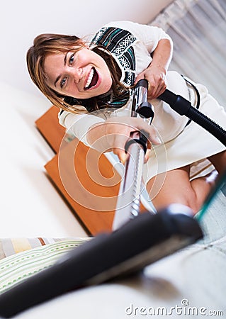 Housewife hoovering surfaces at home Stock Photo