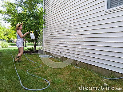 Housewife spraying down the exterior facade Stock Photo