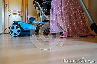 housewife vacuum cleaner vacuuming the floor in the apartment Stock Photo
