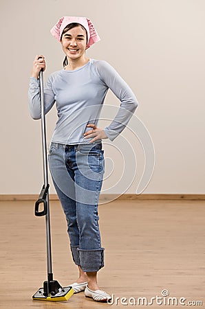 Housewife wearing headscarf and holding mop Stock Photo