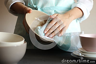 Housewife wipes the dishes with a towel. Stock Photo