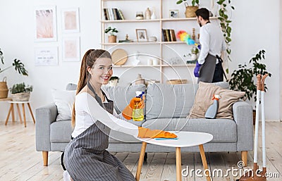 Housework. Woman wipes table, man wipes dust Stock Photo
