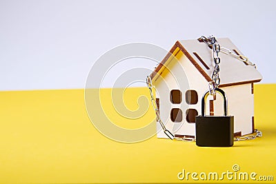 Housing arrest. Castle house. Small toy house and a chain with a lock. Stock Photo