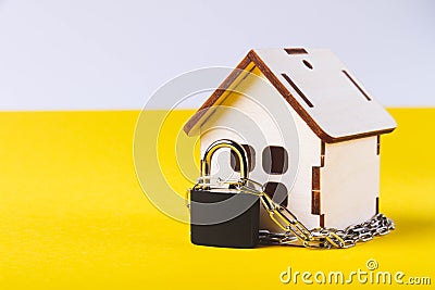 Housing arrest. Castle house. Small toy house and a chain with a lock. Stock Photo