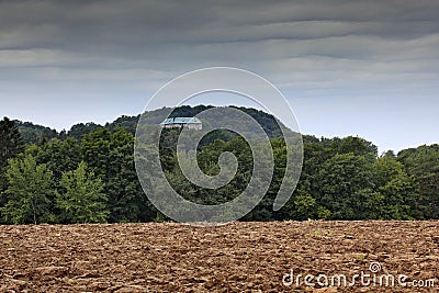 Houska castle in Czech Republic, Bohemia, Europe. State caste, hiden in green forest, dark grey clouds. Tower house in landscape. Stock Photo