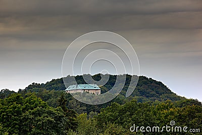 Houska castle in Czech Republic, Central Bohemia, Europe. State caste, hiden in green forest, dark grey clouds. Tower house in lan Stock Photo