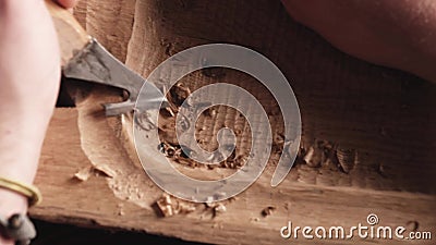 Houtsnijder verwerkt de eikenhouten plank met een mes. ambachtsman maakt een theedienblad. vakmanschap stock video Houtsnijder verwerkt de eikenhouten plank met een mes. ambachtsman maakt een theedienblad. vakmanschap stock video