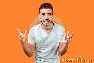 How could you? Portrait of annoyed frustrated brunette man standing with raised hands, asking why. indoor studio shot on Stock Photo