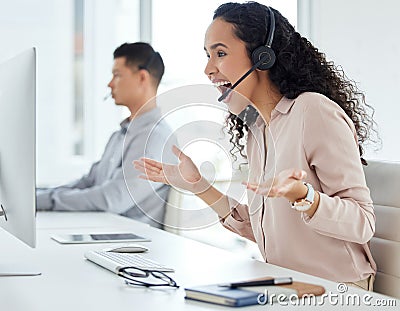 How does she do it. a young call centre agent cheering while working on a computer in an office with her colleague in Stock Photo