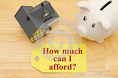 How much can I afford message on a gift tag with a model house with a piggy bank Stock Photo