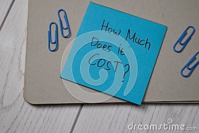 How Much Does it Cost? write on sticky note on wooden table Stock Photo