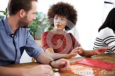 How should we go about this. two design professionals having a discussion while seated at a table. Stock Photo