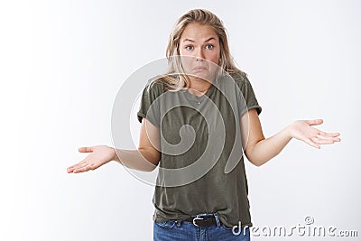 How should I know. Portrait of awkward unaware and clueless beautiful blond woman with short hairstyle shrugging with Stock Photo