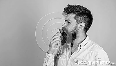 That is how tastes summer. Man handsome hipster with long beard eating strawberry. Hipster enjoy juicy ripe red Stock Photo