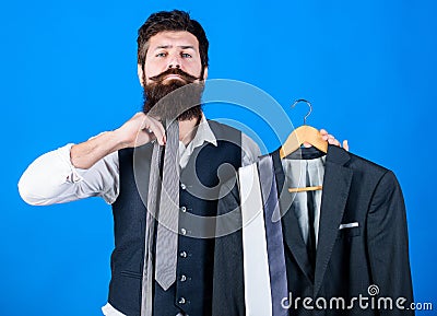 How about this tie. Brutal hipster holding colorful tie collection and suit jacket. Bearded man matching neck tie color Stock Photo