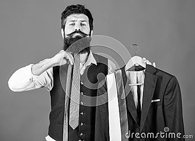 How about this tie. Brutal hipster holding colorful tie collection and suit jacket. Bearded man matching neck tie color Stock Photo