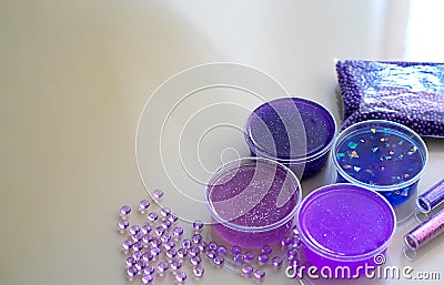 How to make fluffy slime at home. Defocused lilic, violet, blue slimes inside plastic boxes. Stock Photo