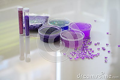 How to make fluffy slime at home. Defocused lilic, violet, blue slimes inside plastic boxes. Stock Photo