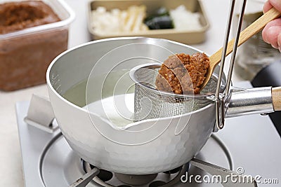 How to make miso soup. Add miso paste Stock Photo