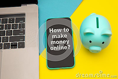 How to make money online - concept of passive income with message on a mobile phone. Moneybox near laptop and mobile Stock Photo