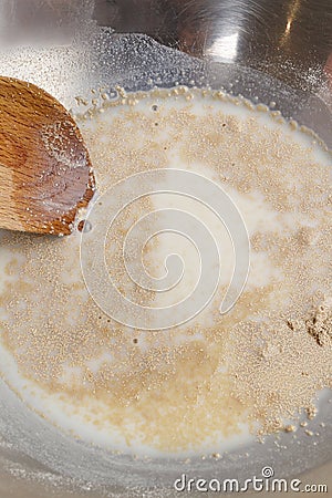 How to make yeast dough - step by step: mix dry yeast with milk Stock Photo
