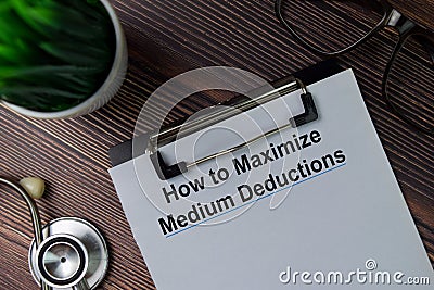 How to Maximize Medium Deductions text write on paperwork isolated on office desk Stock Photo