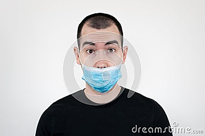 How to Properly Wear a Facemask for COVID-19 Protection. young male stand closeup wear put on face mask. Covidiot Stock Photo