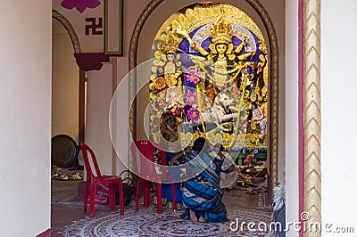 Howrah,India -October 26th,2020 : Bengali sari clad mother, showing Goddess Durga to child, Durga inside old age decorated home. Editorial Stock Photo