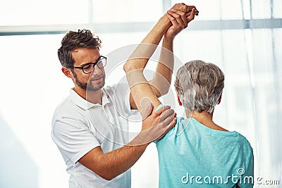 Hows that rotator cuff. a senior woman working through her recovery with a male physiotherapist. Stock Photo