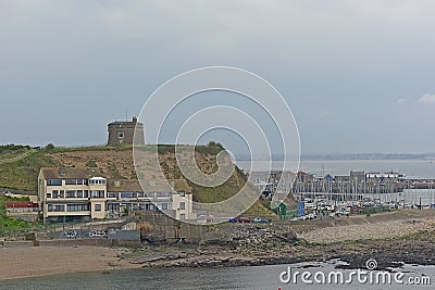 Howth harbor with sailing boat and Martello tower on a cliff Editorial Stock Photo