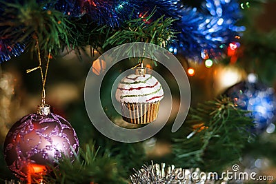 Ð¡hristmas ball in shape of muffin on Christmas tree. Stock Photo