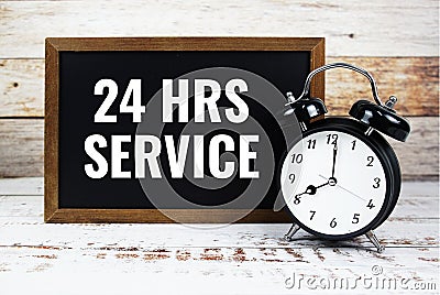 24 HRS Service text message with alarm clock on wooden background Stock Photo