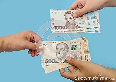 500 and 1000 hryvnia in female hands. The concept of corruption. to give a bribe. Giving or taking money. Hands with hryvnias isol Stock Photo