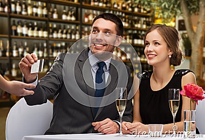 Hsppy couple paying with credit card at restaurant Stock Photo