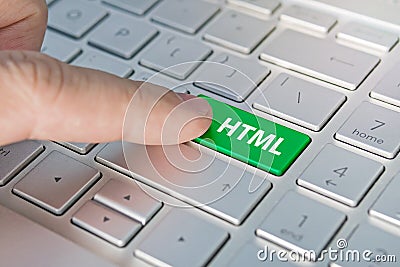 HTML computer language. writing on button modern of gray laptop. Finger presses the button. Programmer for work. Stock Photo