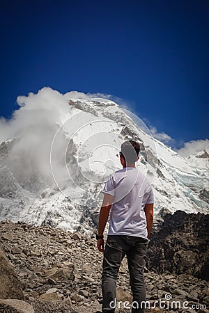 Huaraz/Peru - Oct.09.19: hiker admires the snowy peak after climbing the mountain Editorial Stock Photo