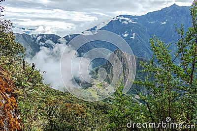 Huayna Picchu, or Wayna Pikchu, mountain in clouds rises over Machu Picchu Inca citadel, lost city of the Incas Stock Photo