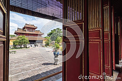 Hue, Vietnam - June 2019: view over traditional Vietnamese temple through open decorated entrance doors Editorial Stock Photo