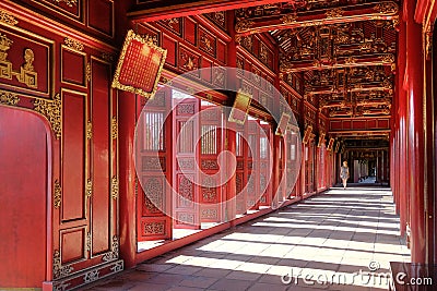 Hue / Vietnam, 17/11/2017: Woman passing through a red ornamental pavillion in the Citadel complex in Hue, Vietnam Stock Photo