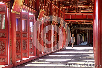 Hue / Vietnam, 17/11/2017: Woman passing through a red ornamental pavillion in the Citadel complex in Hue, Vietnam Stock Photo