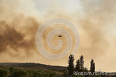 Huelva, Bonares, Spain August 05 2023: Infoca helicopter, Firefighters, prepares the trajectory to pour water on the forest fire Editorial Stock Photo