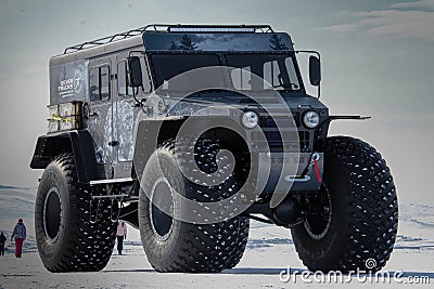 Huge Bigfoot truck running over junk cars, stunt, performance. Monster auto show demonstration, entertaining people Editorial Stock Photo
