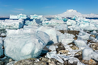 Huge blue icebergs driftingand laying ashore with Sermitsiaq mountain in the background, nearby Nuuk city, Greenland Stock Photo