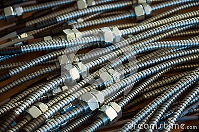 Huge bunch of metal flexible shield tubes with nuts Stock Photo