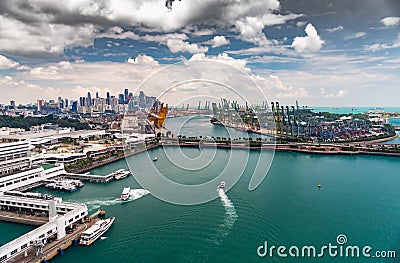 The huge busiest logistic port in Singapore, plenty of cranes to move containers, huge cargo ships in the background Stock Photo
