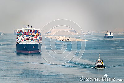 Huge cargo ships navigate through Suez Canal. Shipping canal in Egypt. Concept of transportation and logistics Editorial Stock Photo